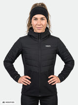 Frau, die eine schwarze Halti Valimo Hybrid Insulation Jacke Damen mit Kapuze und gesteppten Einsätzen trägt.