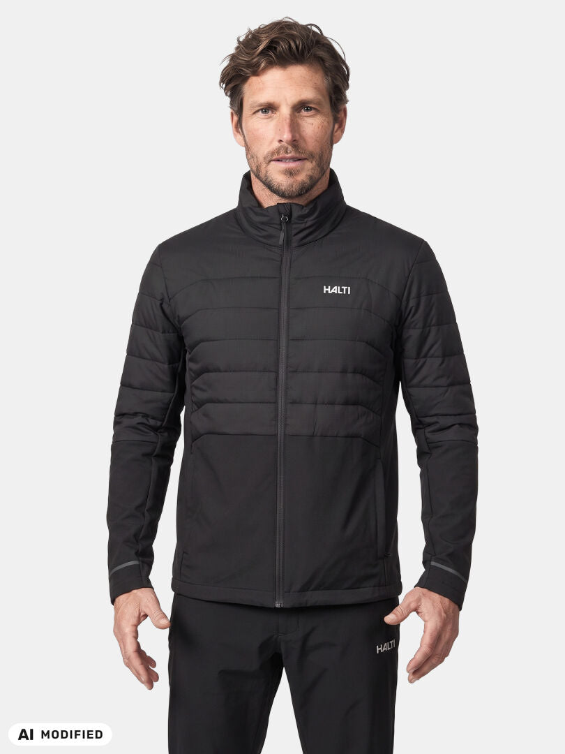 Ein Mann in einer schwarzen Halti Valimo Hybrid Insulation Jacke für Herren steht mit dem Blick nach vorne vor einem schlichten weißen Hintergrund.