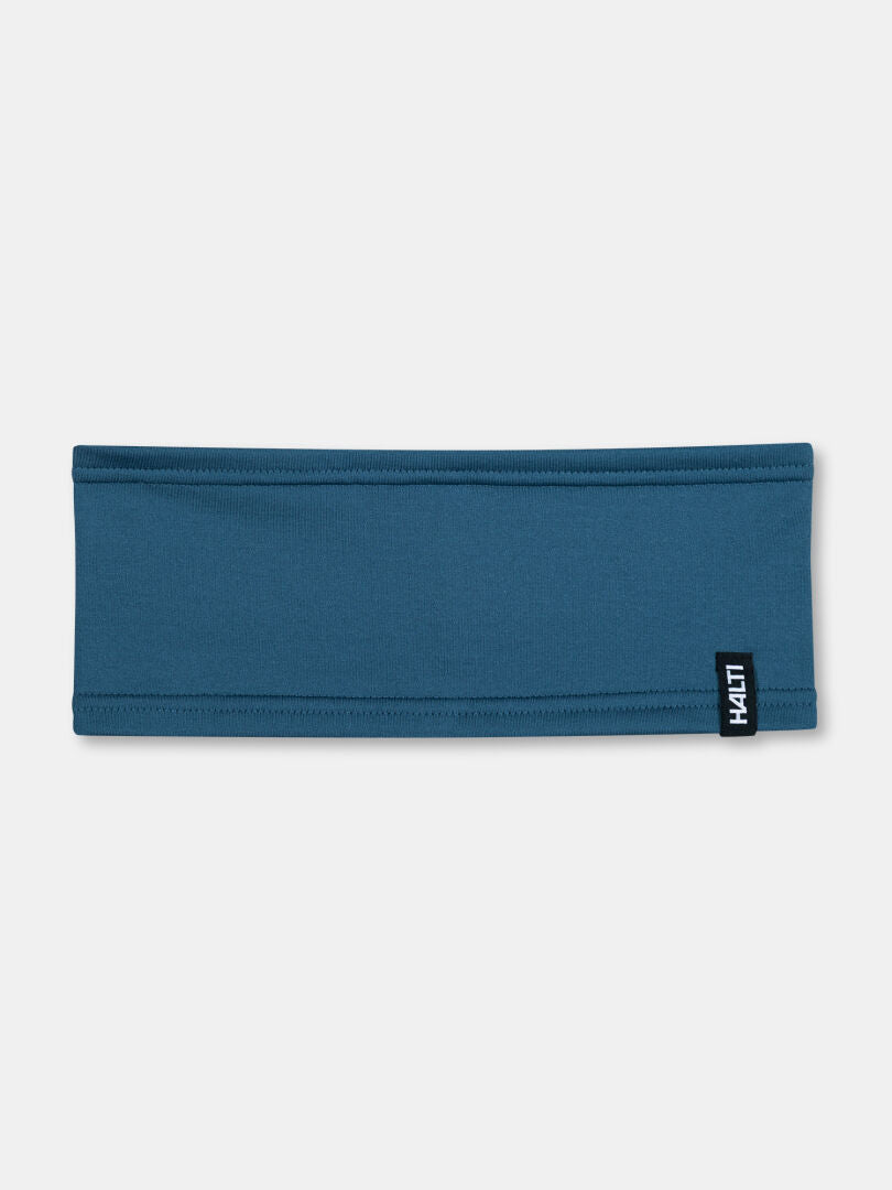 Das Loiva Band von Halti ist ein schlichtes blaues Stirnband aus recyceltem Polyester mit einem kleinen schwarzen HAUT-Label.