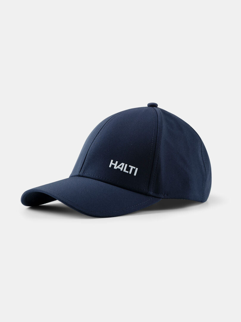 Halti Mattas Baseballkappe in Marineblau mit weißem Logo und UPF 50+ Schutz, abgebildet auf hellem Hintergrund.