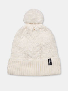 Die Halti Hile Mütze ist weiß, mit Zopfmuster, Pom-Pom, Fleecefutter und schwarzem LIVHAT-Label am Rand.