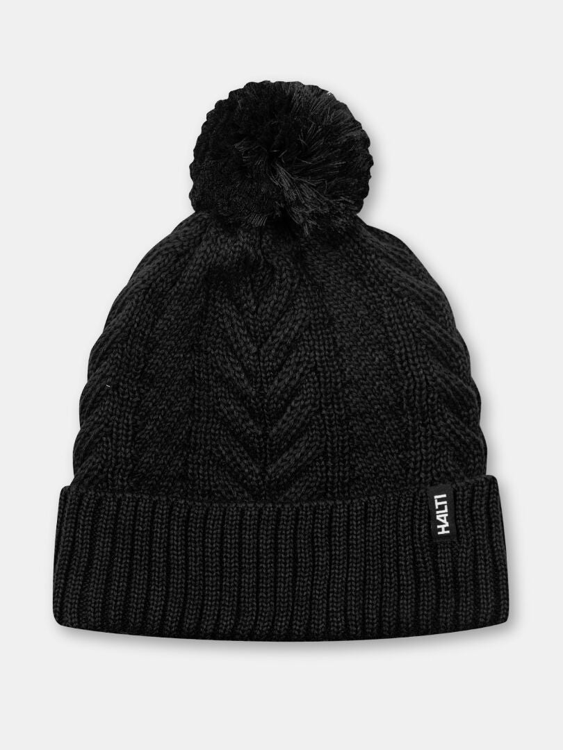 Halti Hile Mütze: Schwarze Strickmütze mit Fleecefutter, Bommel und HAITI-Etikett – ein warmes Must-have für den Winter.