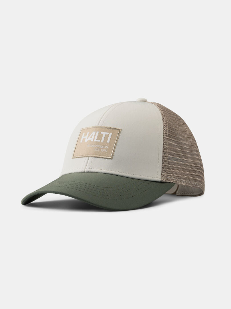 Die Halti Koskelo Trucker Cap besteht aus beigefarbenem und grünem recyceltem Polyester, einem Netzrücken und einem Halti-Logoaufnäher auf der Vorderseite.