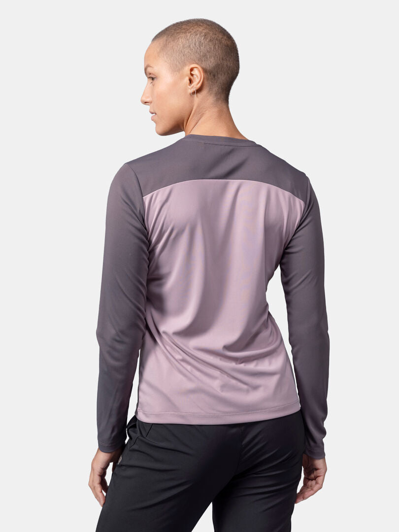 Eine Person mit kurzen Haaren trägt ein Halti Salves Trainingsshirt Damen und eine schwarze Hose, von hinten gesehen.