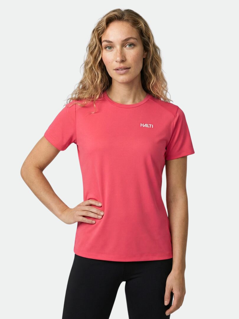 Eine Frau in einem rosa Halti Salves T-Shirt Damen aus recyceltem Polyester steht vor einem schlichten hellen Hintergrund.