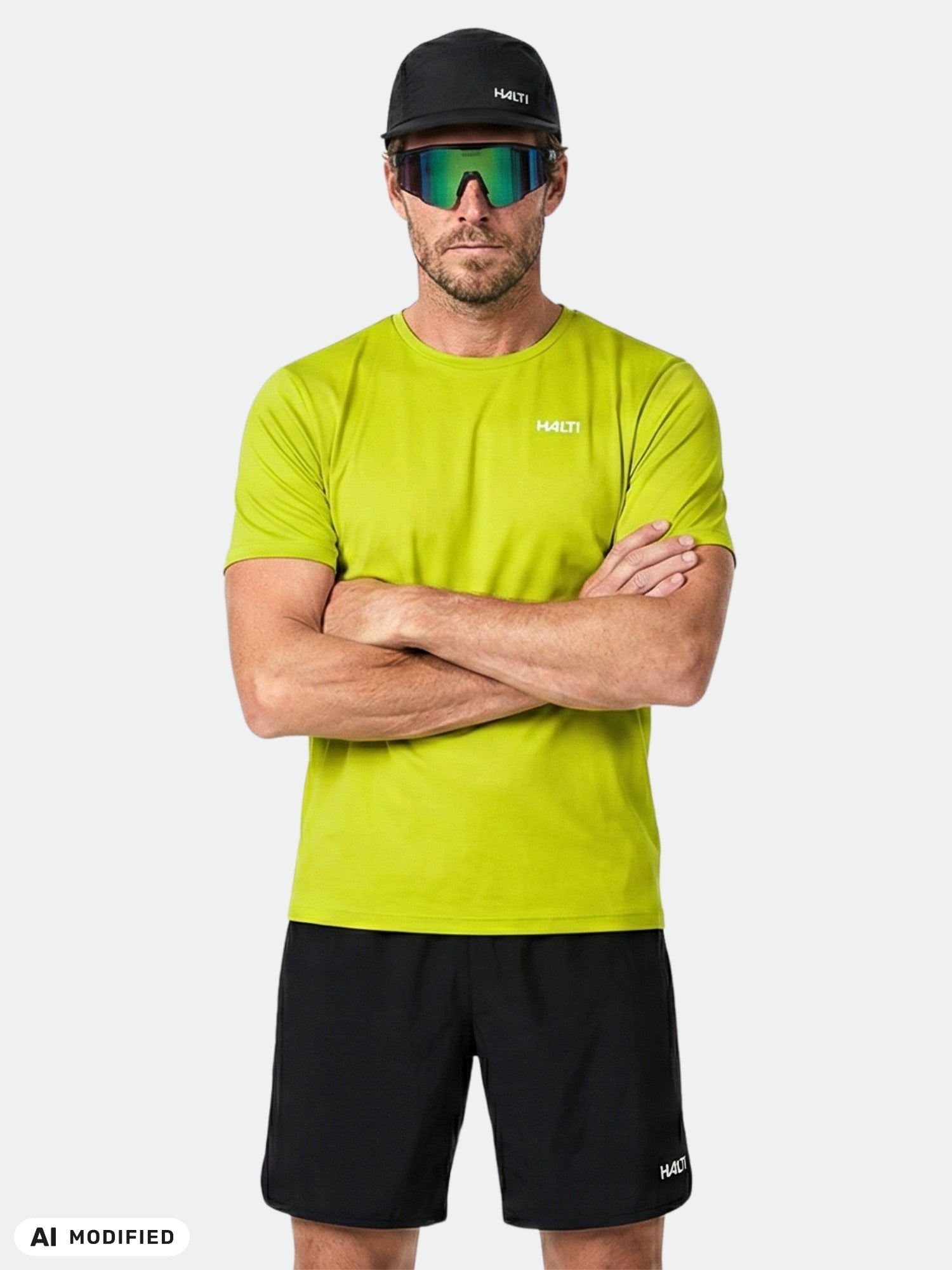 Ein Mann in einem limettengrünen „Halti Salves“-T-Shirt für Herren steht mit verschränkten Armen da, bereit für Outdoor-Aktivitäten.
