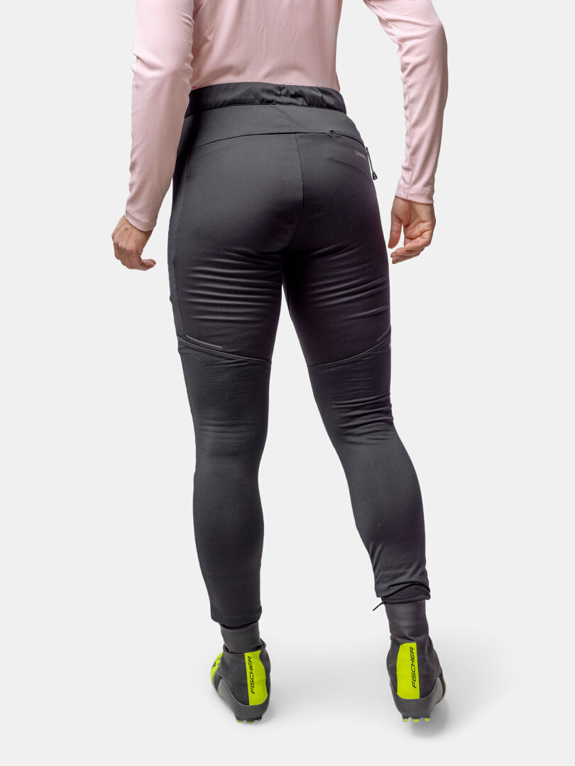 Person in pinkem Longsleeve, Halti Framover Langlauftights Damen, und Stormwall Schuhen-bereit für das Wintertraining.