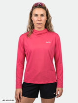 Eine Person trägt den Halti Kaltio Trainingshoodie für Damen in Rosa und schwarzen Shorts und blickt vorwärts vor einem weißen Hintergrund.