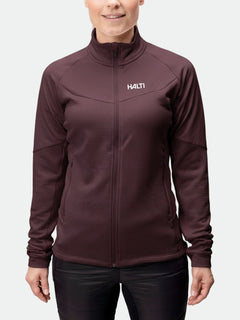 Eine Frau trägt eine kastanienbraune Halti HeatGrid Midlayer Jacke Damen, ideal für Wanderungen, im Stehen und mit entspannten Händen.