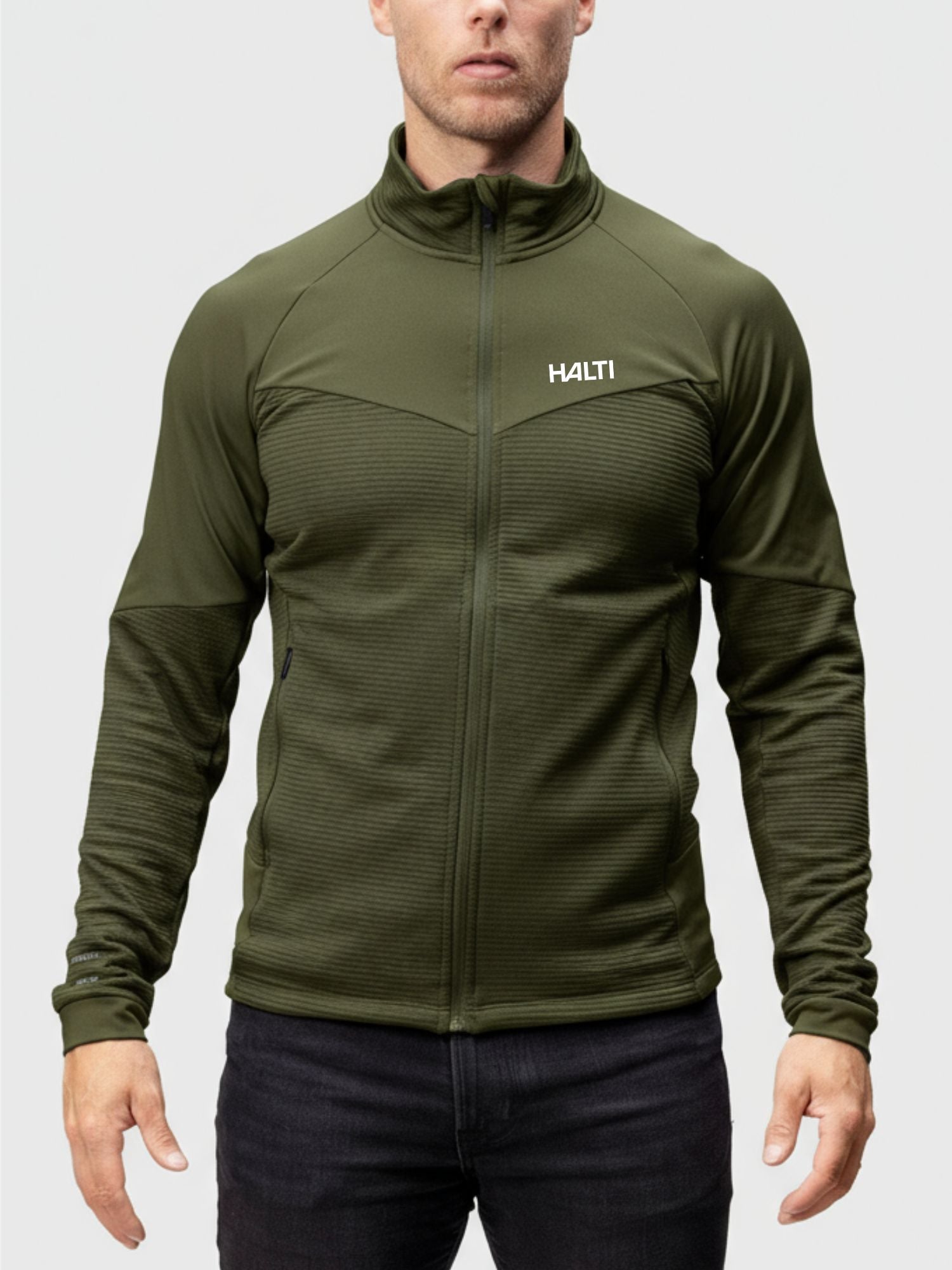 Ein Mann in einer Halti HeatGrid Midlayer Jacke Herren, die für Wärme und Bewegungsfreiheit sorgt.