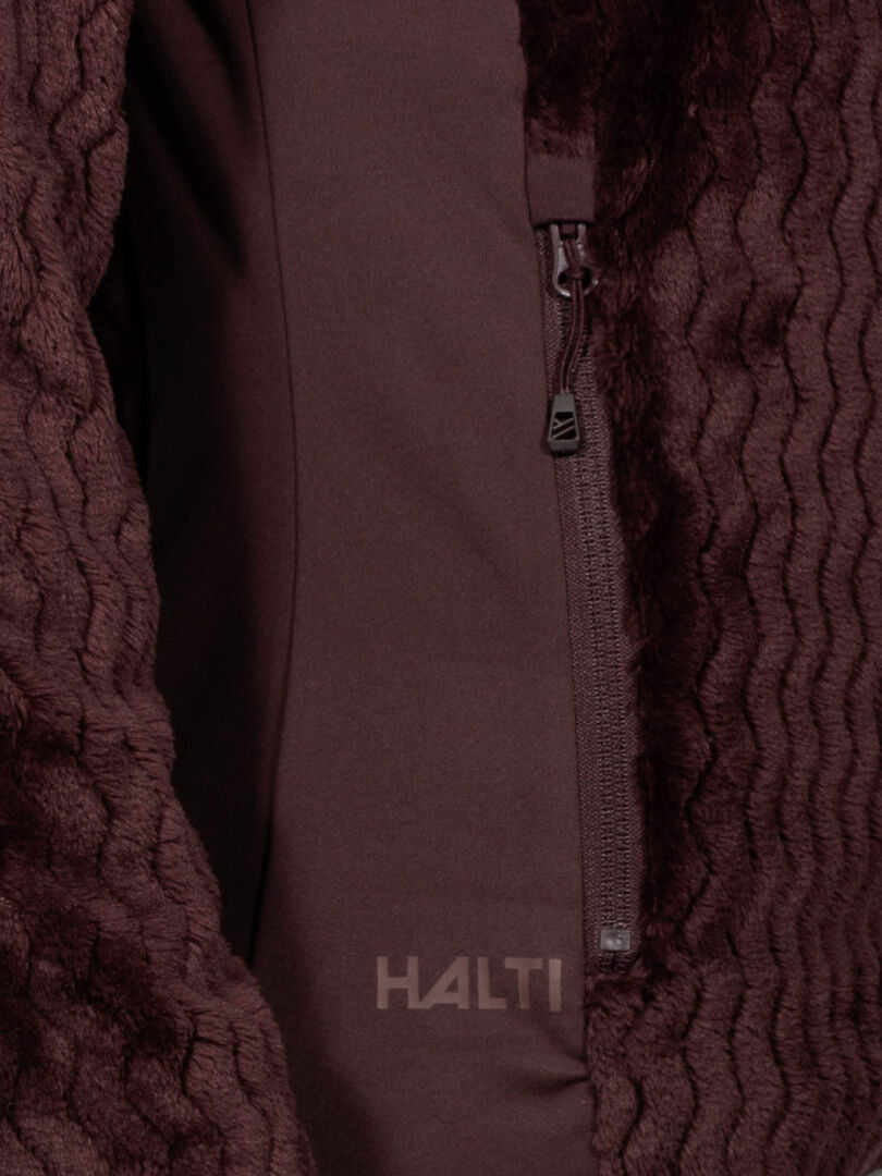 Nahaufnahme des Halti Thermel Midlayer Damen in kastanienbraun, mit Reißverschlusstasche und aufgedrucktem Halti-Logo.