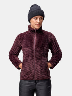 Eine Person trägt einen dunkelvioletten Halti Thermel Midlayer Damen, eine schwarze Strickmütze und eine schwarze Hose mit den Händen in den Taschen.