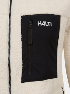 Nahaufnahme einer Halti Lumista Polar Fleece Jacke Damen mit schwarzer Brusttasche, Reißverschluss und weißem Halti-Logo.