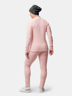 Frau mit Blickrichtung nach außen, bekleidet mit einem rosa Halti Trone Fleece-Shirt, passender Hose, grauer Mütze und weißen Schuhen.