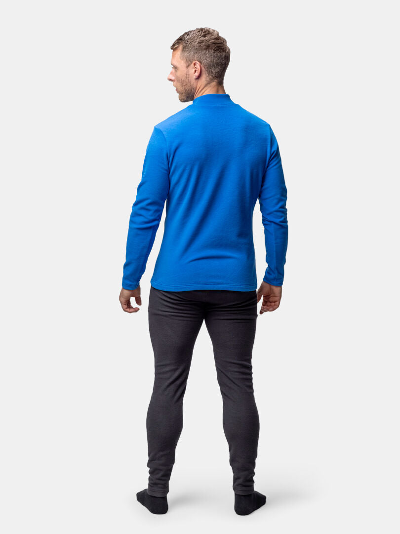 Ein Mann in einem Halti Trone Fleece-Shirt und einer dunklen Hose schaut weg, er trägt schwarze Socken vor einem schlichten Hintergrund.