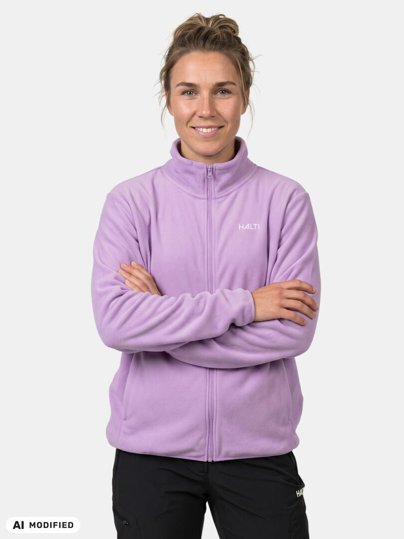 Frau in einer hellvioletten Halti Rockmoon Fleecejacke für Damen, die Arme verschränkt, vor einem weißen Hintergrund posierend.
