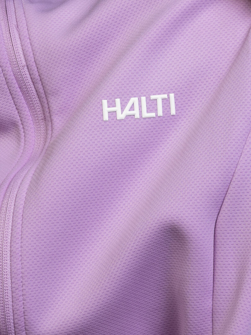 Nahaufnahme der Halti Kivikko Midlayer-Jacke für Damen mit Reißverschluss und Logo – perfekt für Outdoor-Aktivitäten.