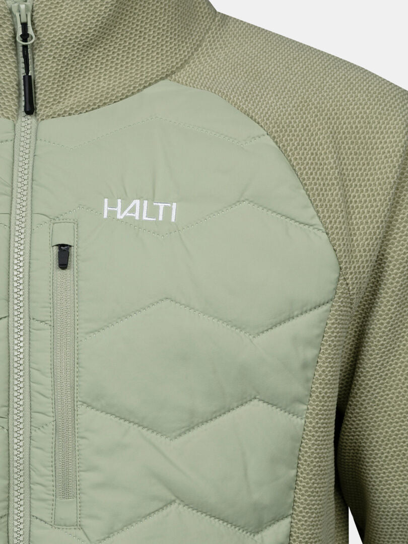 Nahaufnahme einer hellgrünen Halti Suomis Hybrid Layer Jacke für Herren mit Reißverschlusstasche auf Brusthöhe und gestepptem Sechseckmuster.