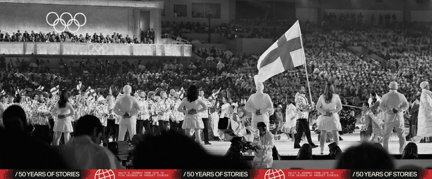 Sportler gehen während einer olympischen Eröffnungsfeier in ein Stadion, einer hält eine Fahne mit einem Kreuz, die Menge im Hintergrund.