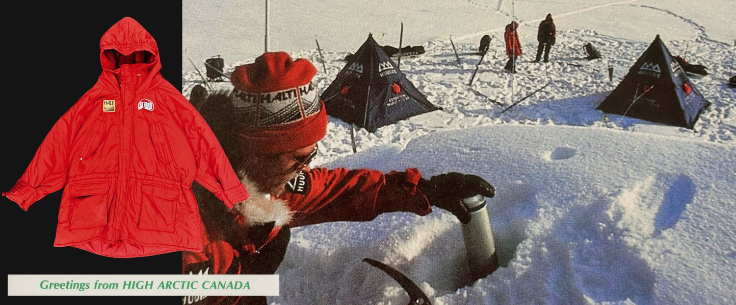 Eine Person in roter Winterkleidung überprüft ihre Ausrüstung im Schnee in der Nähe von Zelten; links ist ein roter Parka zu sehen. Der Text lautet: 
